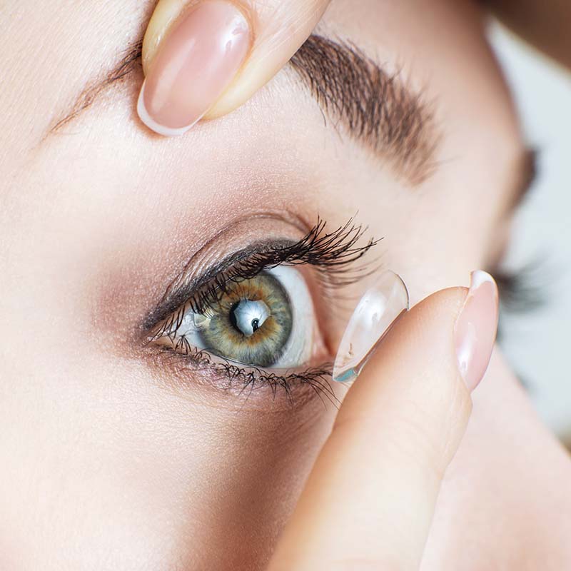 Close-up of a contact lens being placed on an eye